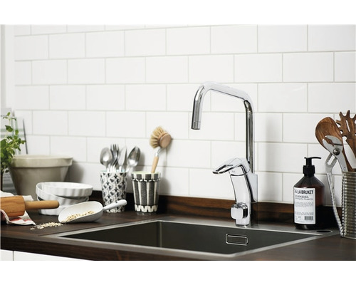 Diskho med blandare och köksredskap framför en kakelvägg