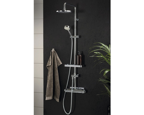 Duschsystem med takdusch, handdusch och termostatblandare på en mörk vägg