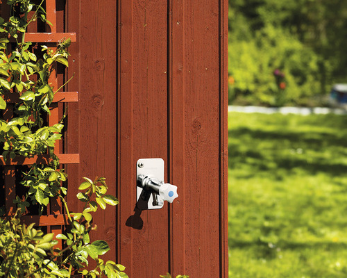 Utomhuskran på trävägg med klätterväxt