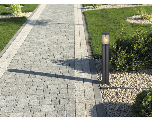 Uteplats med gångväg av gatsten och en väglampa.