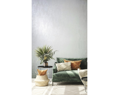 Vardagsrum med grön soffa, kuddar, sidobord och dekorationer för en ljus och inbjudande atmosfär.