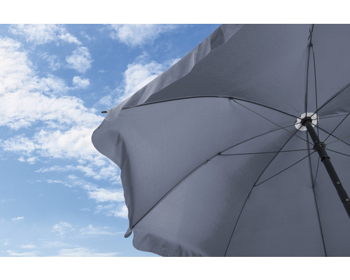 Öppnat parasoll mot blå himmel med moln