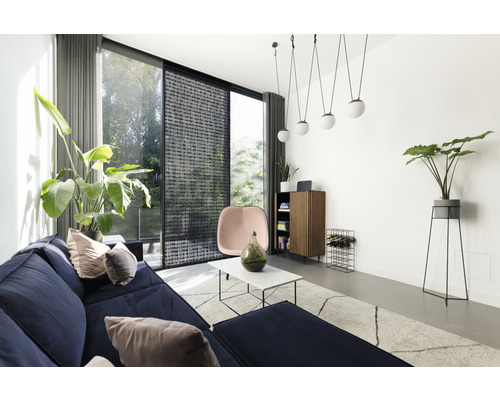 Vardagsrum med soffa, fåtölj, skåp och växter