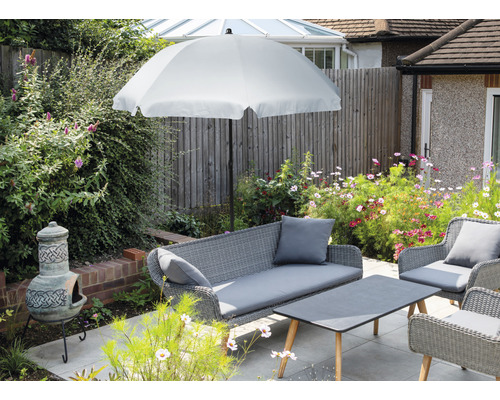 Utemöbelset med parasoll, soffa, fåtöljer och bord på en terrass.