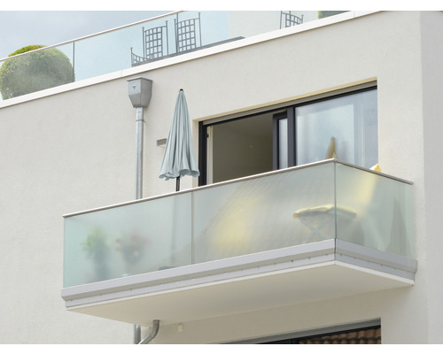 Utomhusvy av en balkong med glasräcke och parasoll
