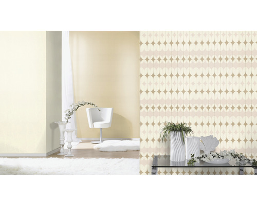 Vardagsrum med mönstrad tapet, fåtölj, matta och dekoration