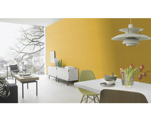 Ljust vardagsrum med gul vägg, skänk och matbord.