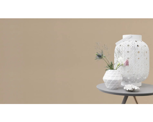 Dekorativ scen med vit lykta, vas och blommor på ett bord