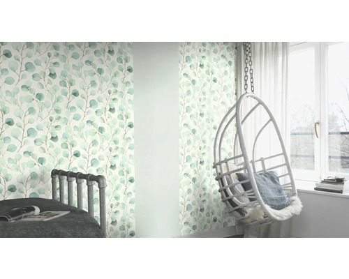 Vardagsrum med tapet med eukalyptusmotiv, säng och hängande stol