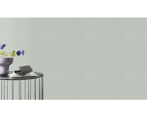 Dekorativ scen med blommor, vas, bok och handväska på ett sidobord