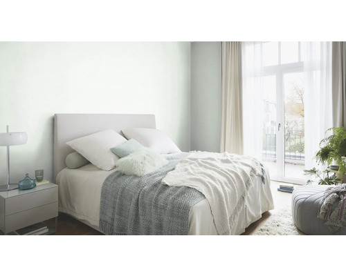 Ljust sovrum med säng, sängbord och dagsljus