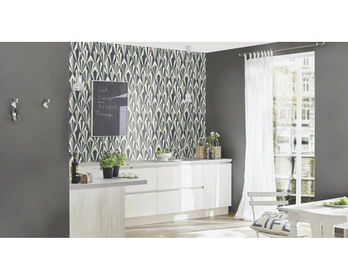 Köksscen med mönstrad tapet, köksmöbler och dekorationer.