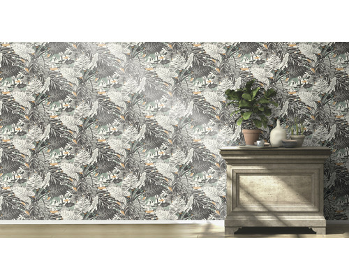 Dekorativt rum med en tapet med bladmönster och en byrå