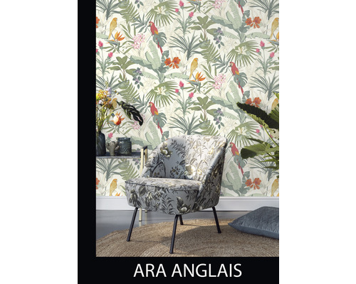 Miljöbild med fåtölj med blommönster och en tapet med blad och fåglar