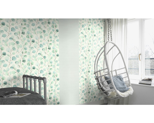 Dekorativt rum med tapet med bladmönster och hängande stol bredvid ett fönster