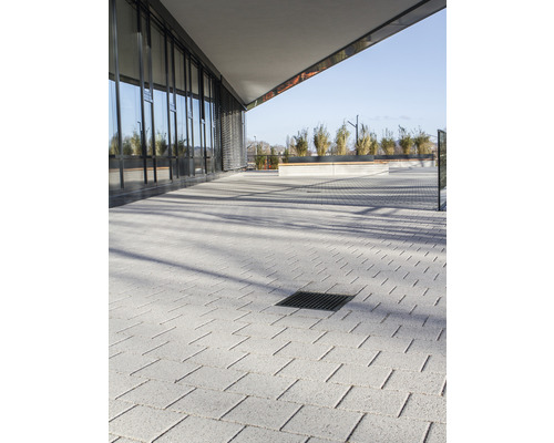 Utomhusområde med gatsten och dräneringsränna