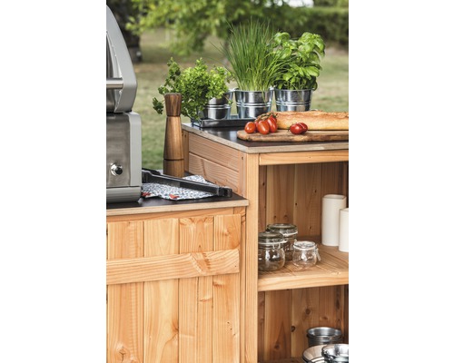 Träkök med grill, örter, tomater och bröd i trädgården