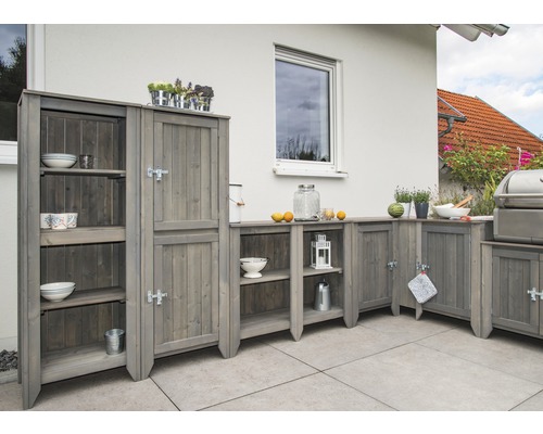 Grått trädgårdskök i trä med skåp och hyllor på en terrass.