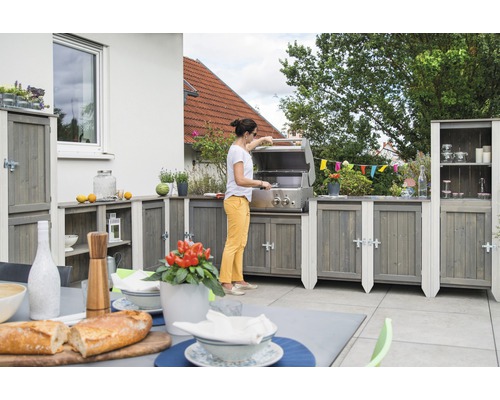 Grillsäsong med utekök i trä och grill i rostfritt stål på terrassen
