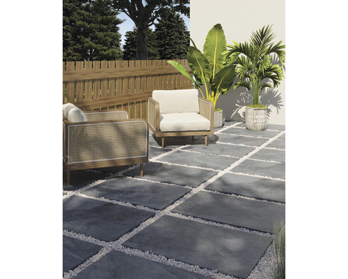 Terrassdesign med grå stenplattor, vita dekorativa grus, två fåtöljer, trästaket och växter