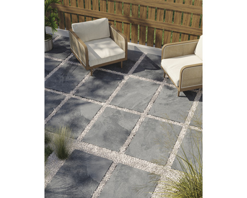 Terrass med stenplattor och grusytor samt två fåtöljer