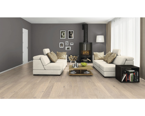 Vardagsrum med ljust trägolv, soffor, öppen spis och dekoration för en mysig atmosfär.