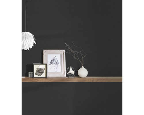 Dekorativa föremål på en trähylla mot en mörk vägg