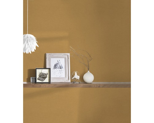 Inredningselement på en vägghylla framför en strukturerad vägg