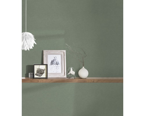 Vardagsrum med mönstrad tapet, vägghylla, dekoration och lampa