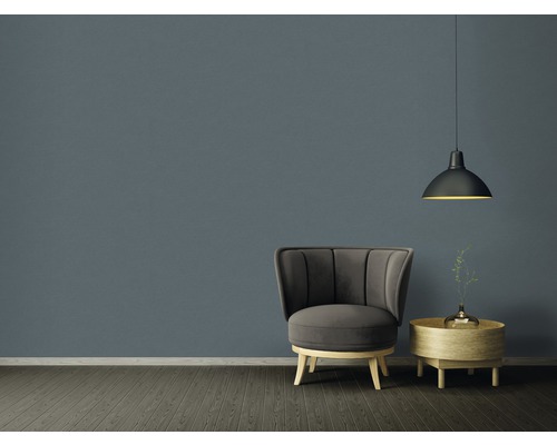 Vardagsrum med fåtölj, bord och taklampa