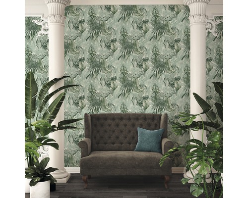 Scen med en soffa och en vägg med bladgrönska tapeter