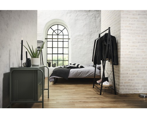 Sovrum med säng, klädställning, byrå och stort fönster