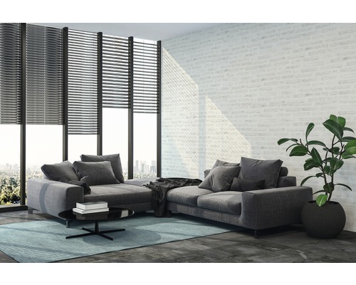 Vardagsrum med grå hörnsoffa, rullgardiner för fönstret och krukväxt