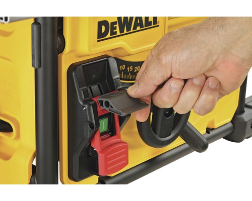 En person använder strömbrytaren på en DeWalt bordssåg.