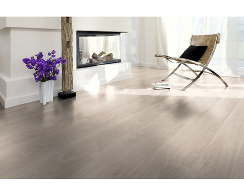 Ljust vardagsrum med laminatgolv, öppen spis och fåtölj