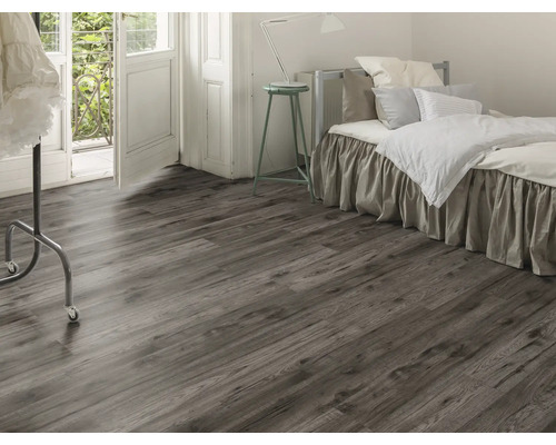 Sovrum med laminatgolv i trälook, säng och balkongdörr