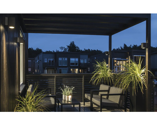 Modern terrass med belysning, trädgårdsmöbler och växter för en ljus och organiserad atmosfär.