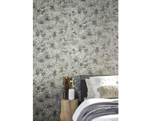 Sovrum med mönstrad tapet, säng och sidobord i trä