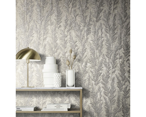 Närbild av en vägg med tapet med bladmönster och dekorativa element på en hylla