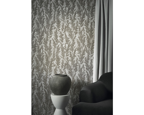 Miljöbild med mönstrad tapet, vas och soffa