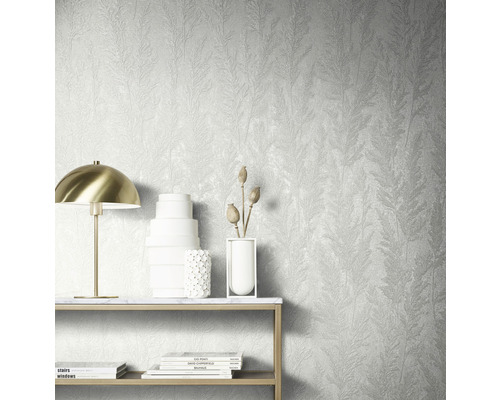 Väggdekoration med strukturtapet med växtmönster, bord med dekoration och lampa