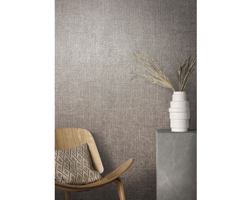 Vardagsrumsmiljö med textiltapet, fåtölj och dekoration