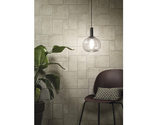 Vardagsrum med väggpaneler i träutseende, lampa och stol med kudde.