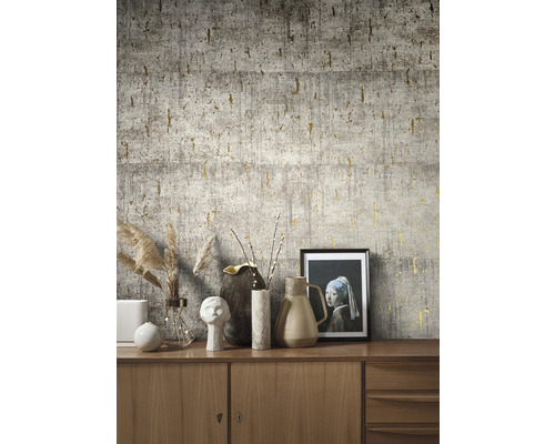 Närbild av en vägg med grå betongtapet och guldfärgade accenter