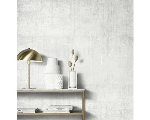 Dekorativt rum med lampa, vaser och böcker på ett bord framför en strukturerad vägg