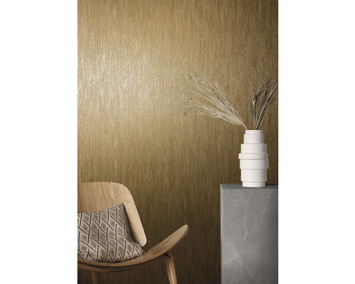 Närbild av en vägg med strukturtapet, en trästol med kudde och en dekoration med vas