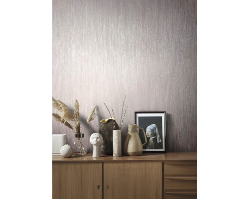 Vardagsrum med mönstrad tapet och byrå med dekorationer