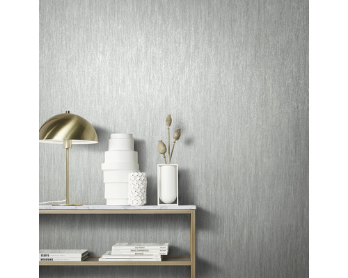 Närbild av en silverfärgad tapet med vertikalt randigt mönster i ett ljust rum.