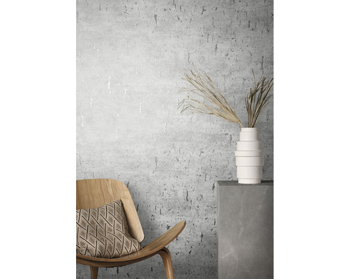 Rumsvy med stol, kudde, vas och prydnadsgräs framför en väggtapet