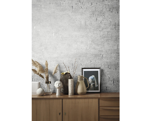 Vardagsrum med mönstrad tapet och dekorativa element på ett träskåp